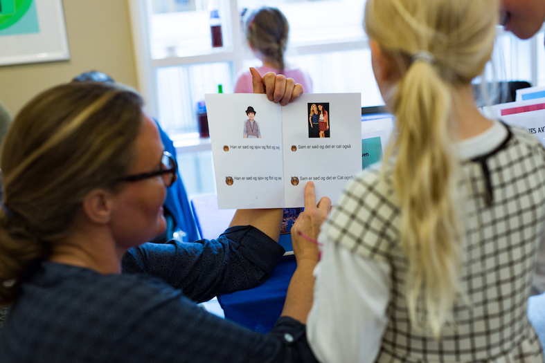 An educator sharing a student-made book with a young reader