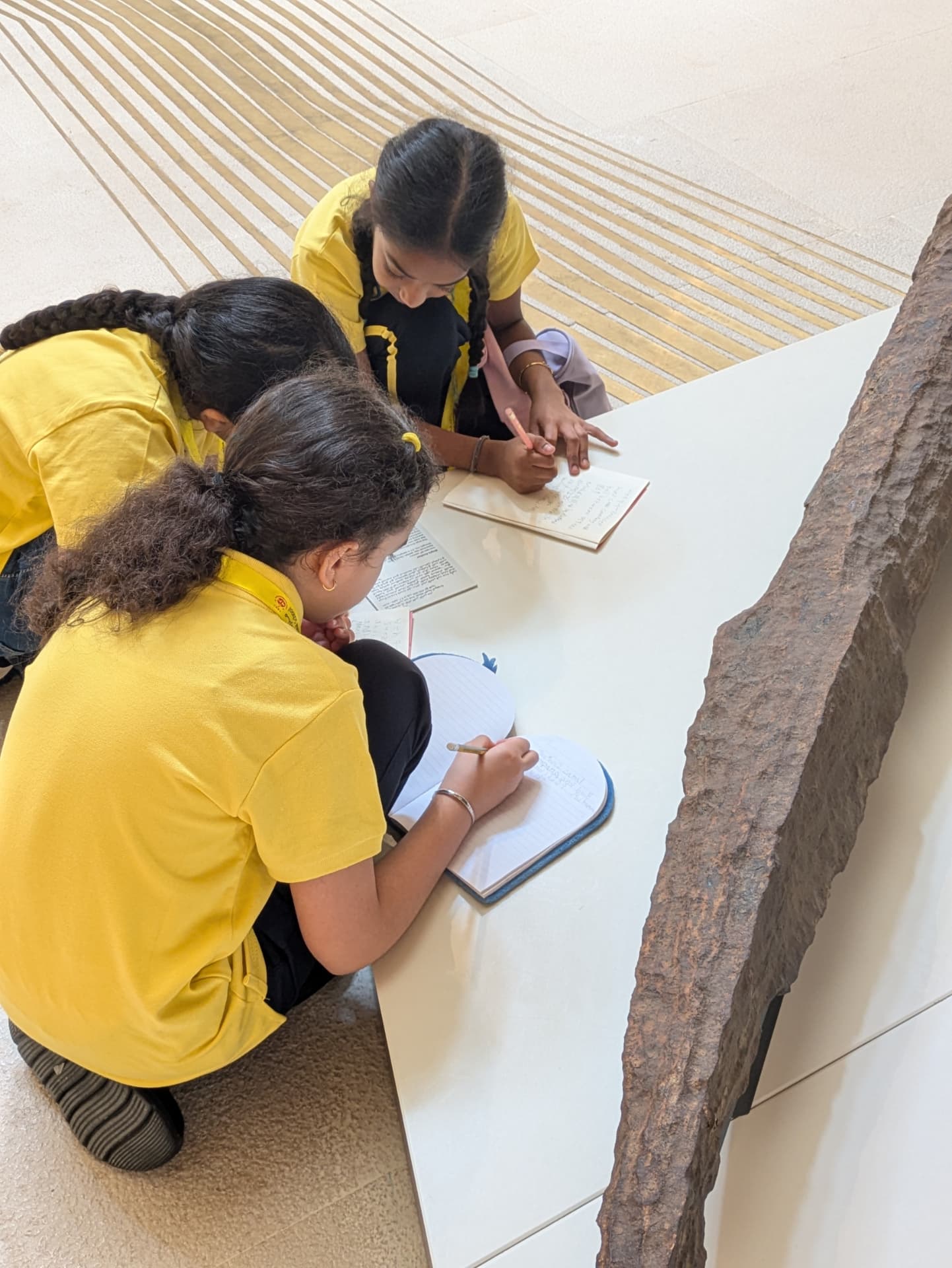 Children writing and drawing on the gallery floor after exploring the exhibition