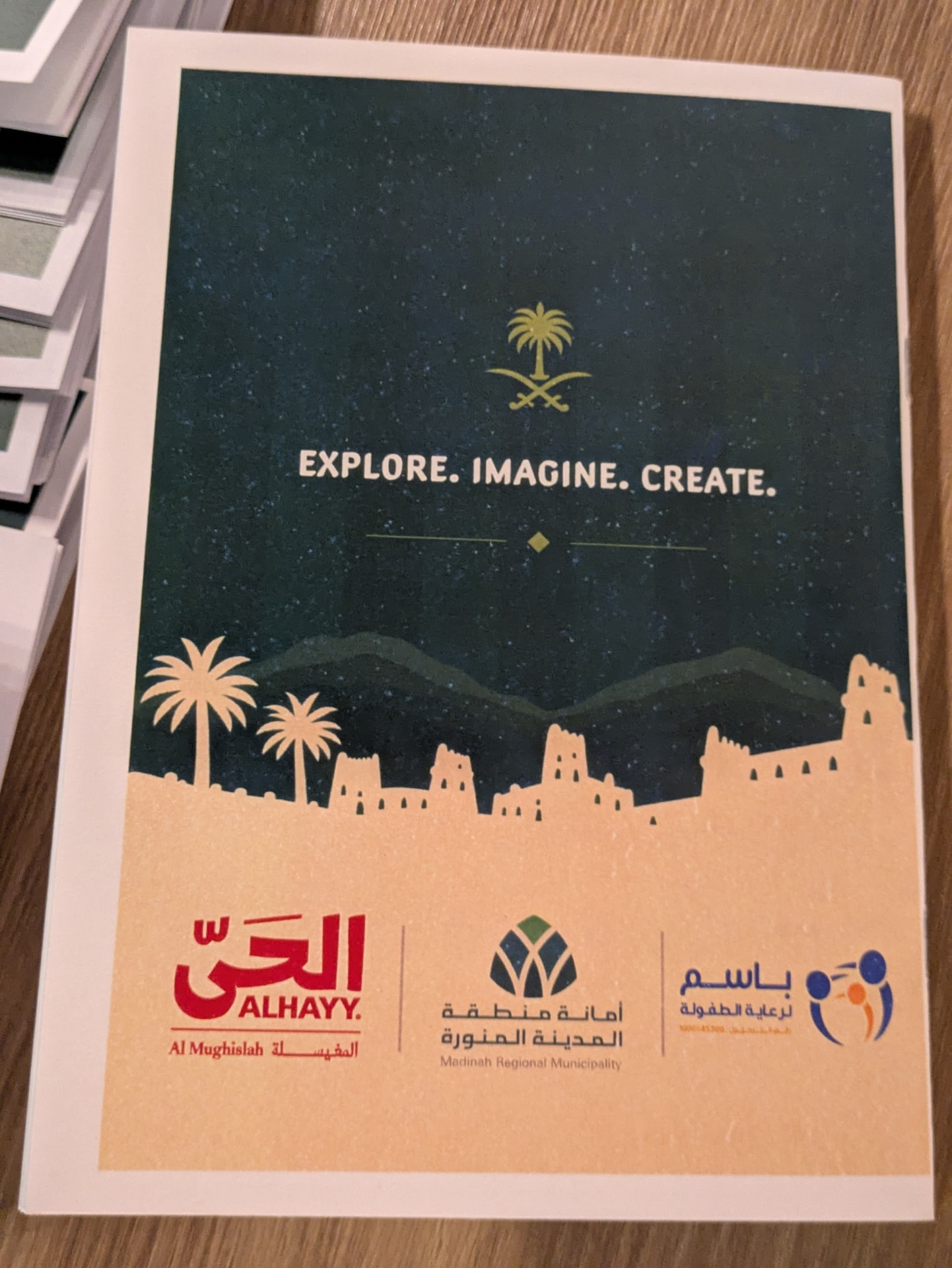 Printed storytelling booklet cover reading Explore, Imagine, Create with partner logos