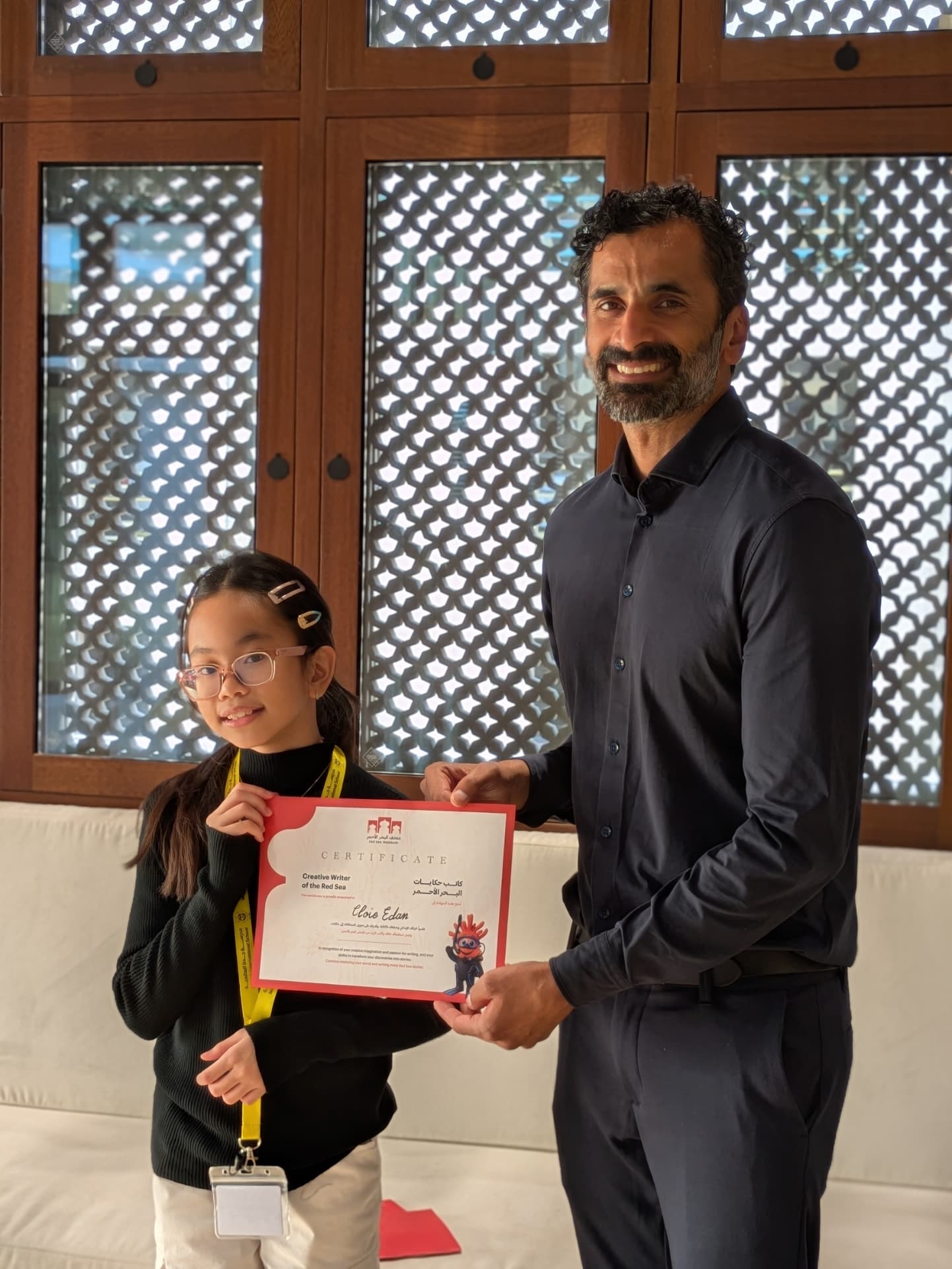 A young participant receiving her Creative Writer of the Red Sea certificate
